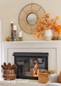 white mantel with round mirror above and fall decorations