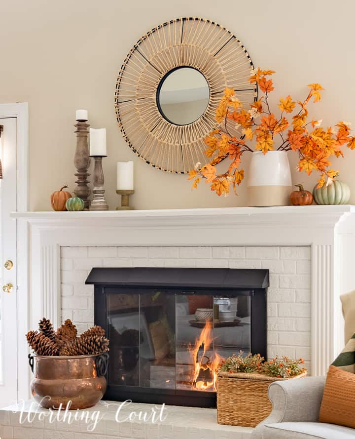 white mantel with round mirror above and fall decorations