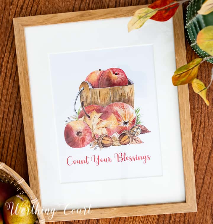 Graphic image of apples in a wood bucket with count your blessings wording below