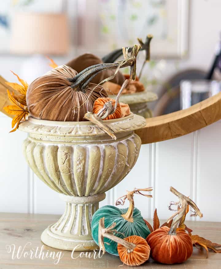 pedestal bowl filled with multiple velvet pumpkins in different colors