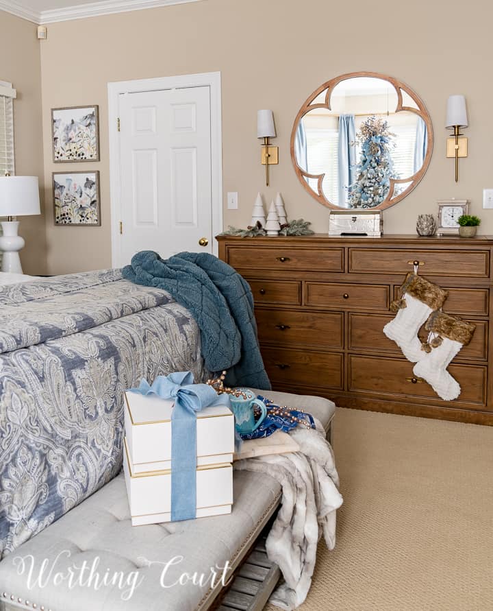 Bedroom dresser with stockings hanging from handles and other various Christmas decorations