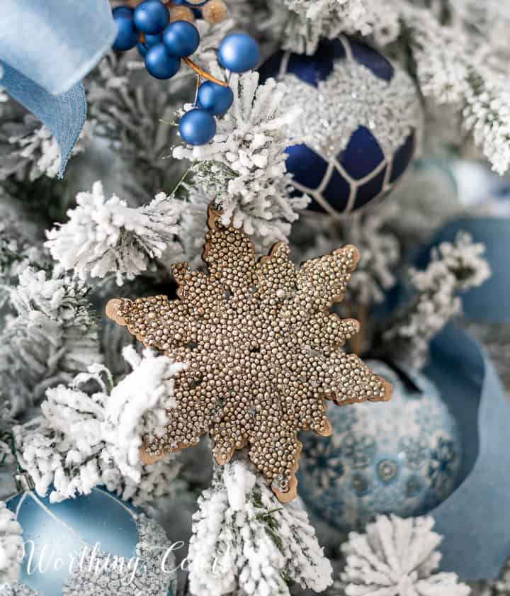 Blue and champagne gold ornaments on a flocked Christmas tree