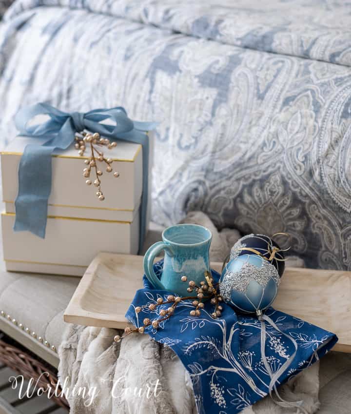 Christmas gifts on a bench with a tray with coffee mug and blue ornaments