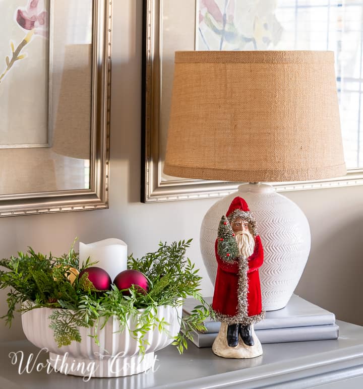 Santa figurine beside white bowl on a gray chest