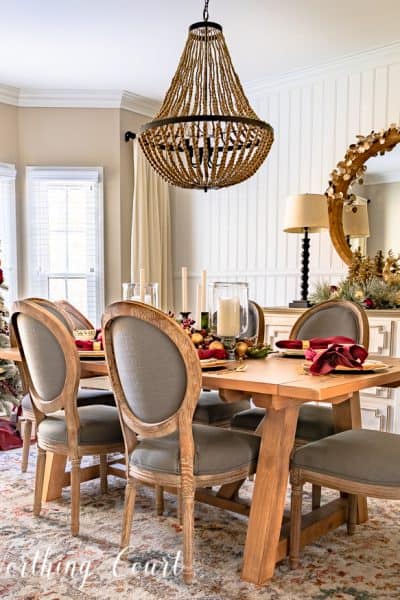 dining room decorated for Christmas with burgundy and gold decor