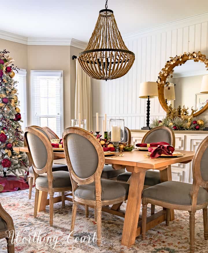 dining room decorated for Christmas with burgundy and gold decor