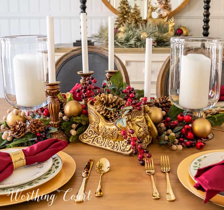 gold and burgundy Christmas centerpieces with glass hurricanes