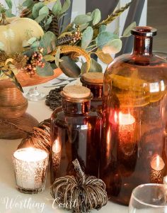 trio of brown glass bottles in part of a Thanksgiving tablescape