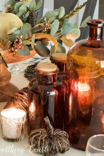 trio of brown glass bottles in part of a Thanksgiving tablescape