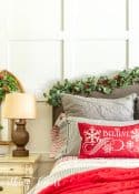 bed in front of white wall with gray, red and white bedding