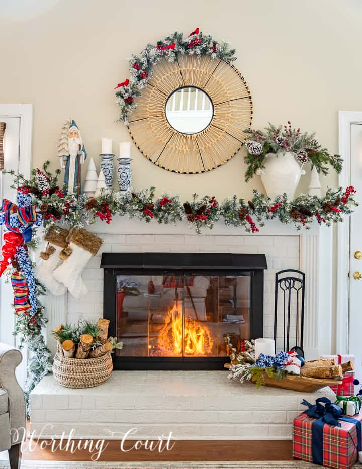 Fireplace decorated for Christmas with a garland and blue, red and white decorations