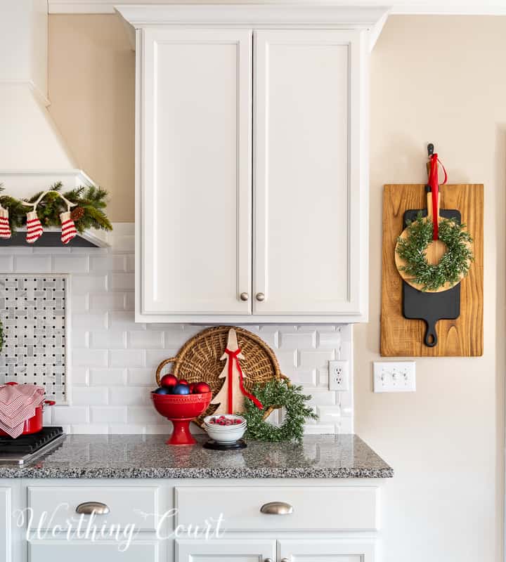 Christmas vignette on kitchen counter with white cabinets and granite counters