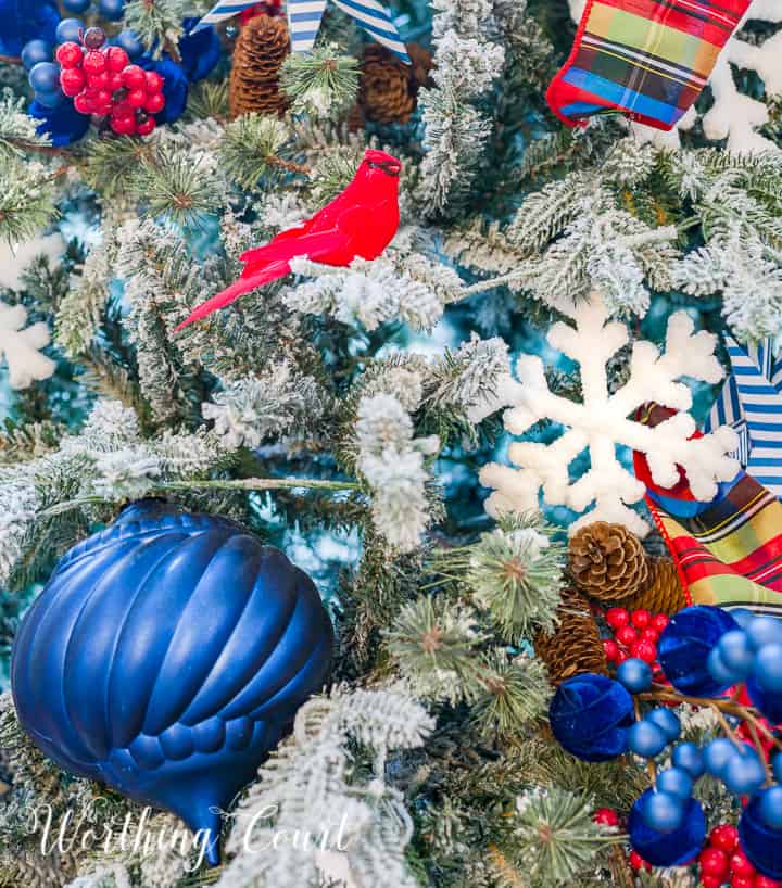 blue white and red decorations on a flocked Christmas tree