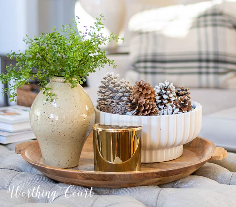 round wood tray on upholstered coffee table with neutral winter decor