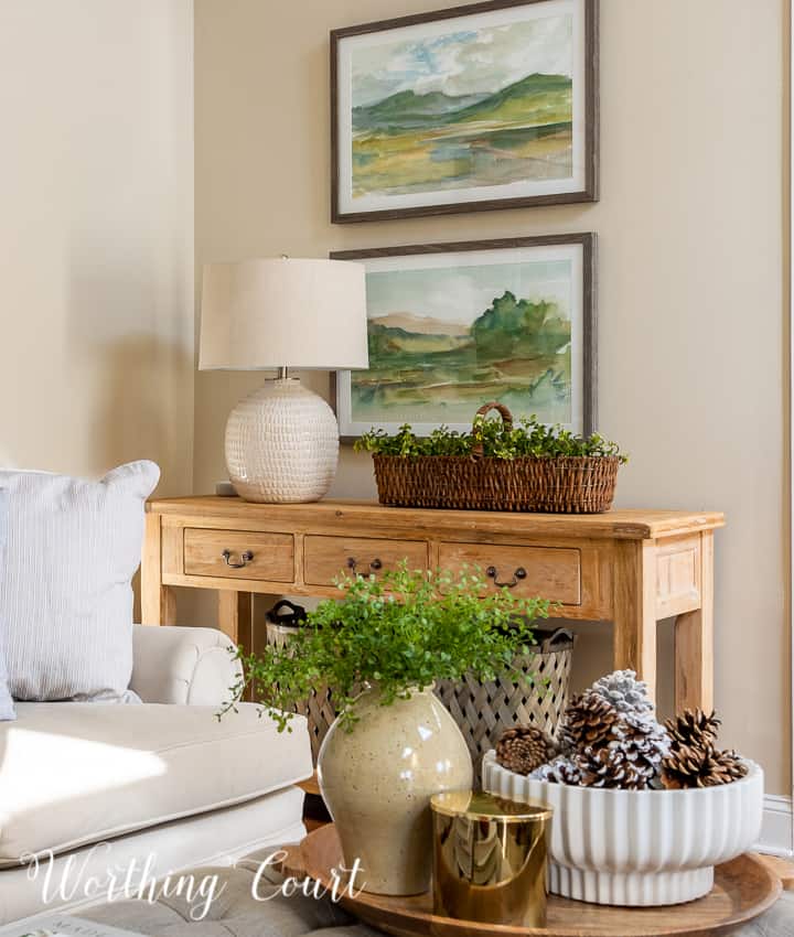 natural wood console table with lamp, landscape art and winter accessories