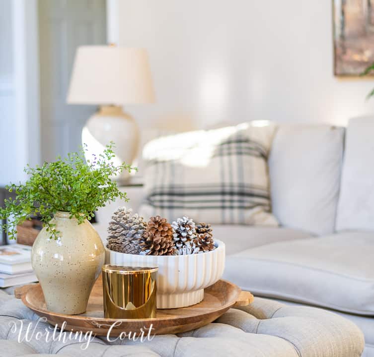 round wood tray on upholstered coffee table with neutral winter decor
