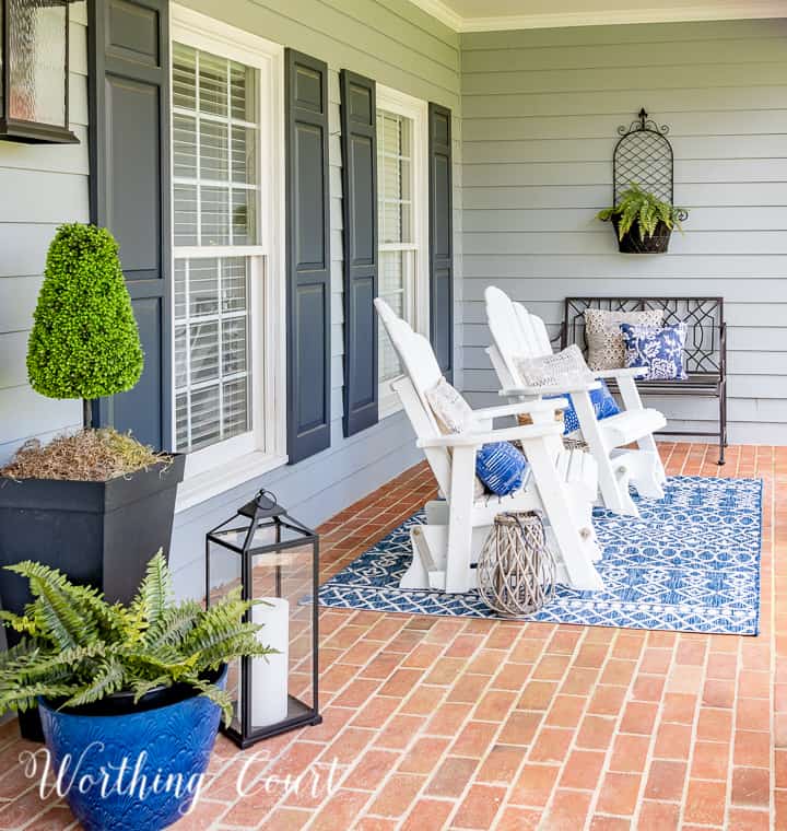 white gliders on a porch with a brick floor