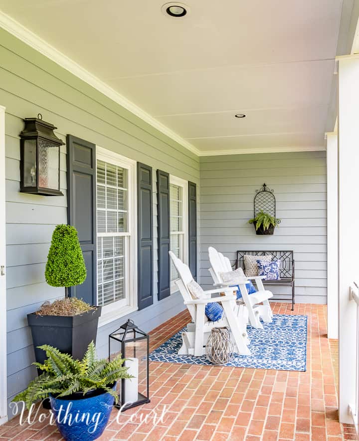 front porch with white Adirondack style gliders and blue and white spring decor