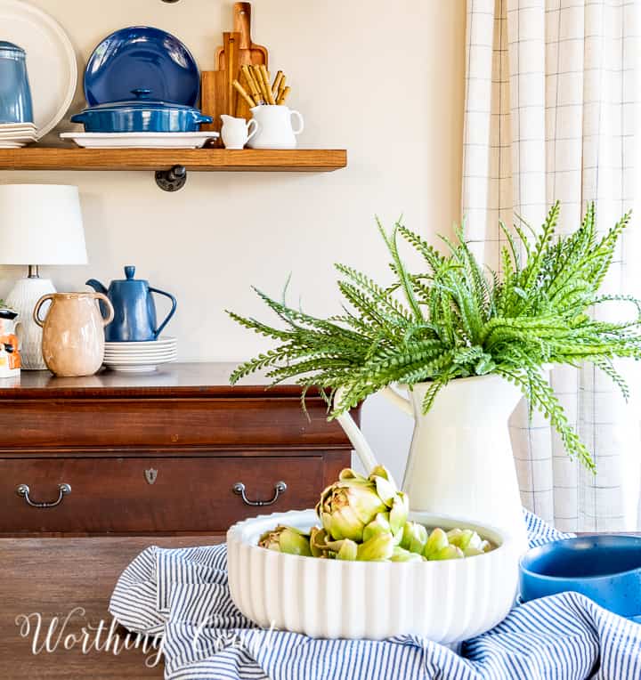 partial view of open shelves and a centerpiece with spring decor