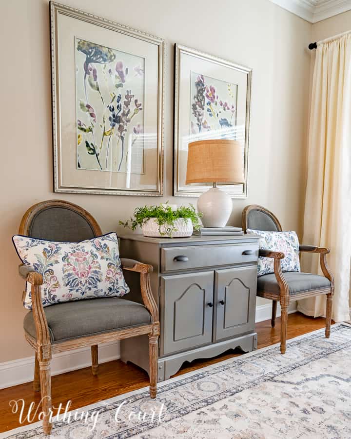 gray dining chairs beside gray chest with multi colored artwork