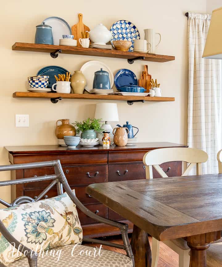 dining table and chair in front of sideboard with open shelves above decorated with blue and white accessories