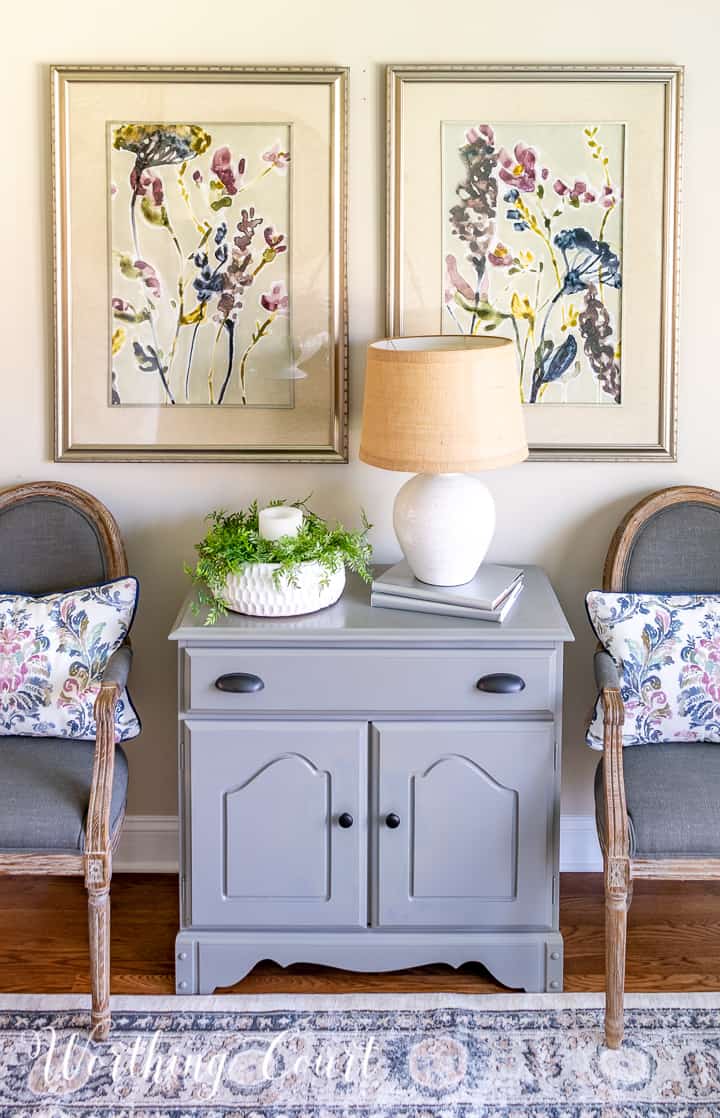 gray dining chairs beside gray chest with multi colored artwork