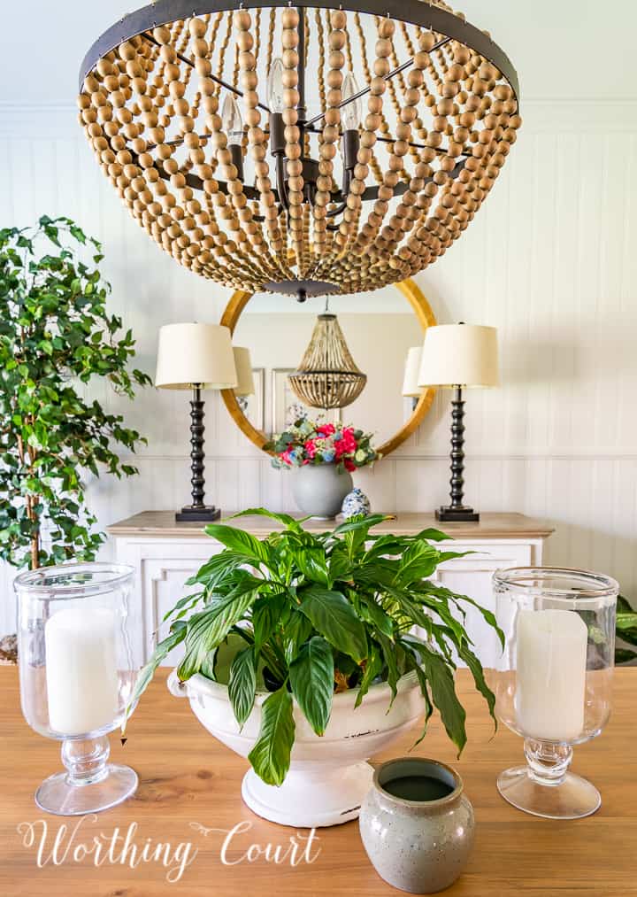 view of round mirror above dining room sideboard looking across centerpiece