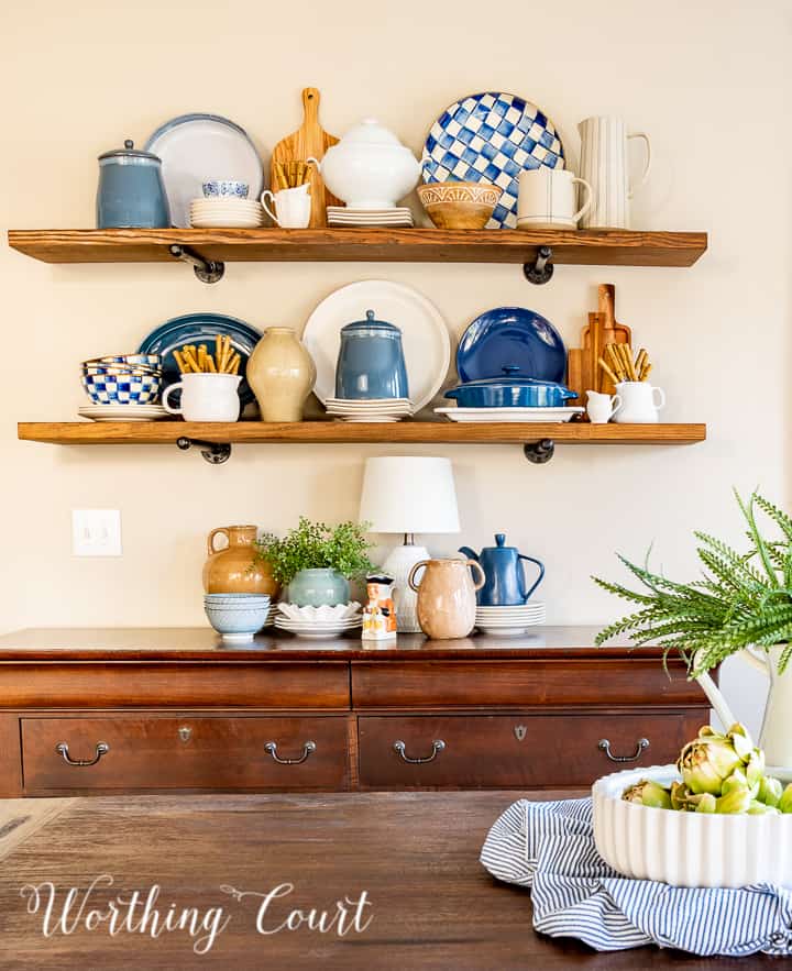 wood open shelves above a sideboard with blue and white accessories