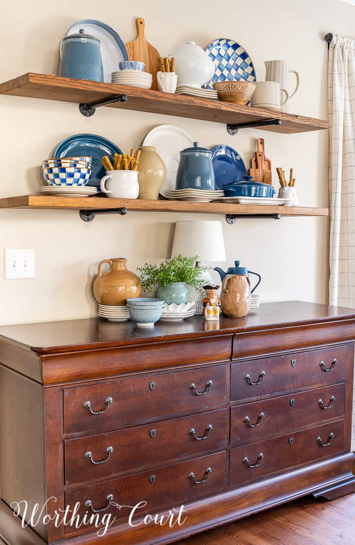 wood open shelves above a sideboard with blue and white accessories
