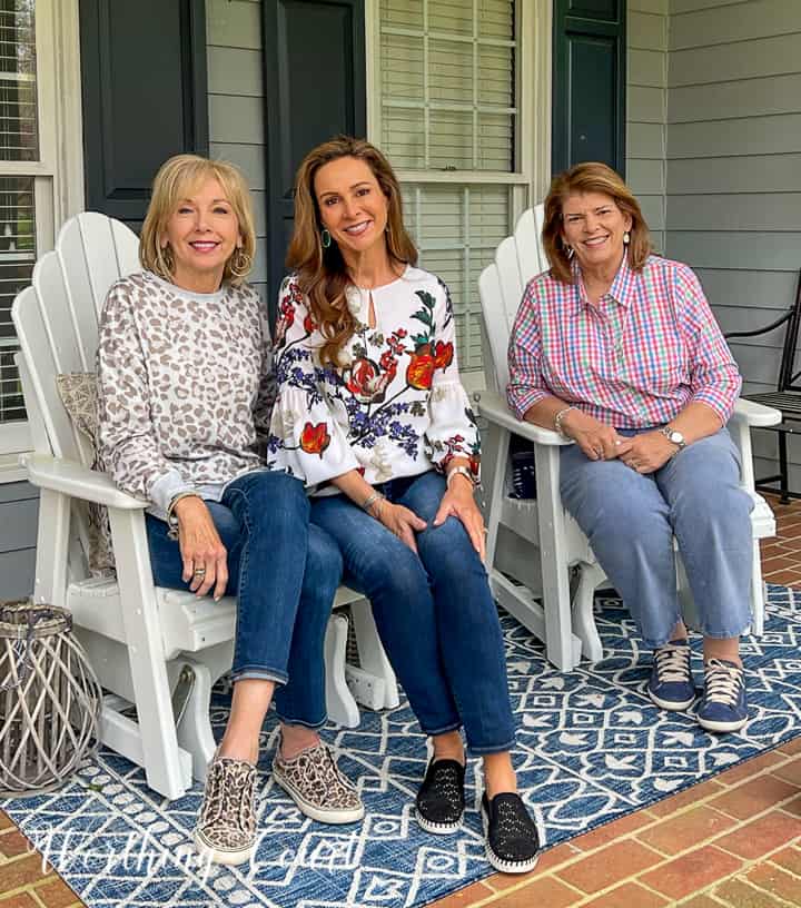 3 women sitting in chairs on a porch