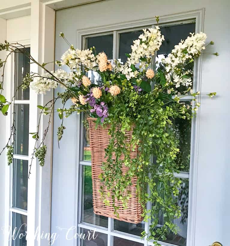 hanging door basket filled with white flowers and greenery