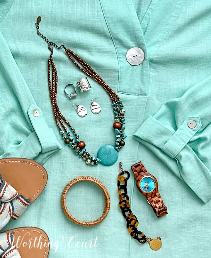 various jewelry lying in an aqua shirt