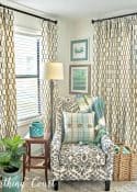 accent arm chair in corner between to windows with draperies