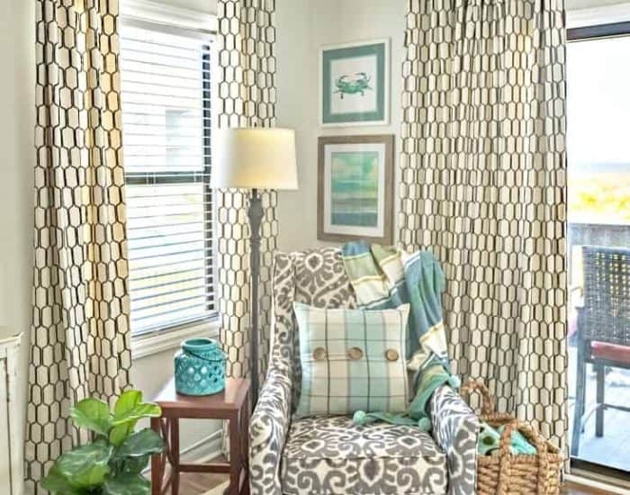 accent arm chair in corner between to windows with draperies