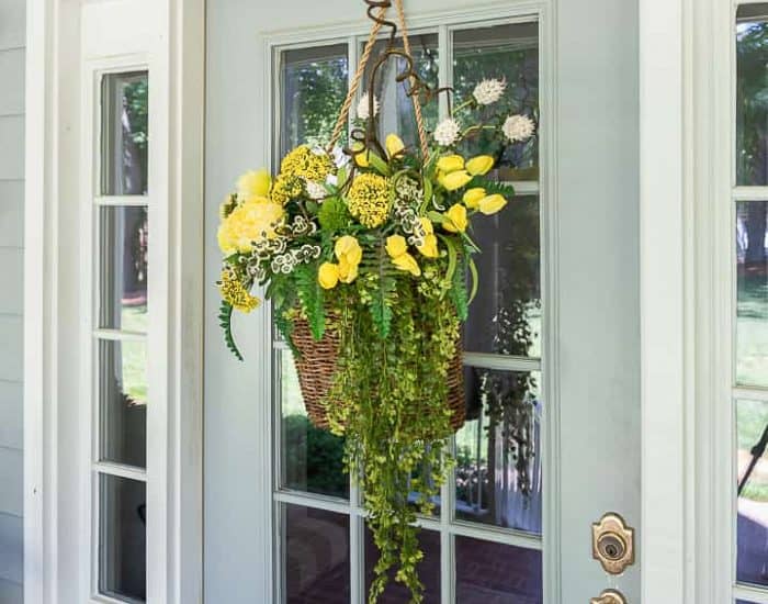 basket of yellow flowers hanging on a front door