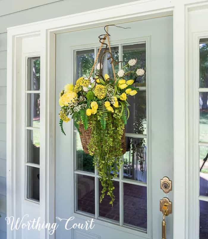basket of yellow flowers hanging on a front door