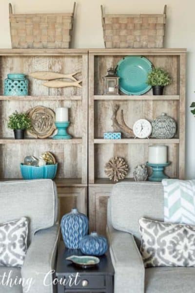 gray bookcases decorated with coastal accessories