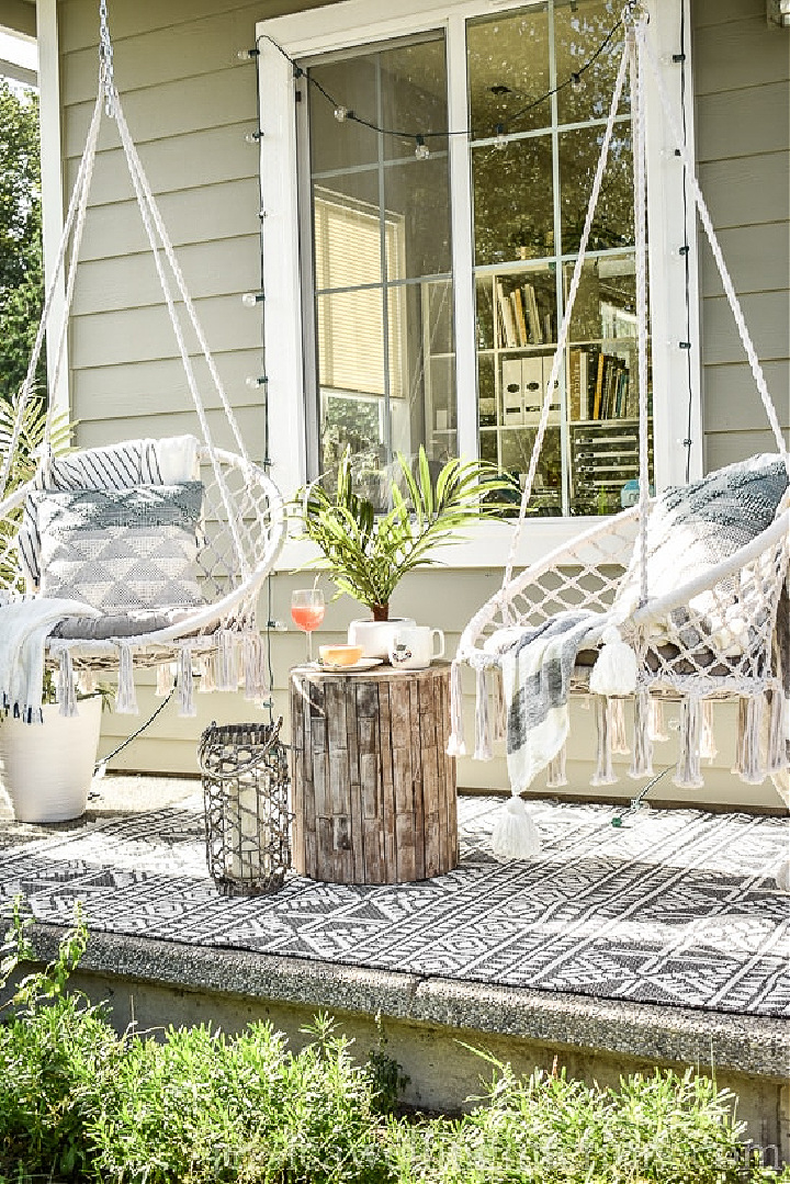 two hanging chairs on a small front porch