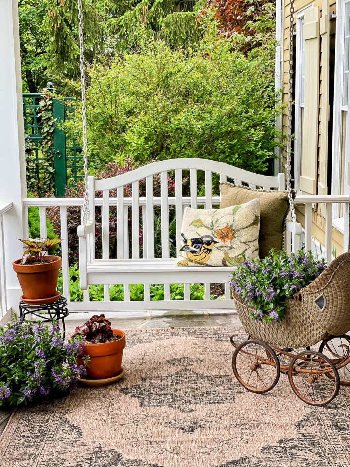 white porch swing on a small front porch