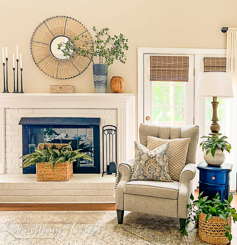 white brick fireplace decorated for summer with an arm chair beside it