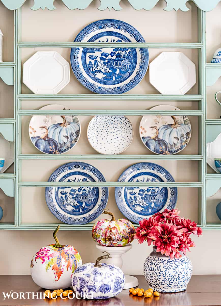 display of three diy chinoiserie pumpkins in front of a plate rack