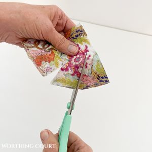 cutting slits into a napkin to prep it for decoupage on a pumpkin