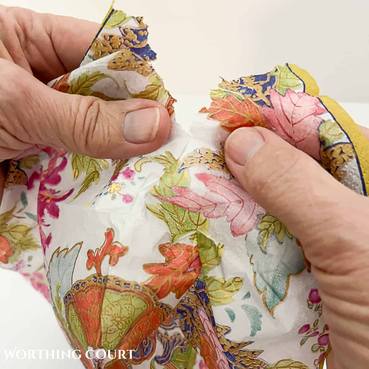 image of tearing around the pattern in a napkin to decoupage a pumpkin