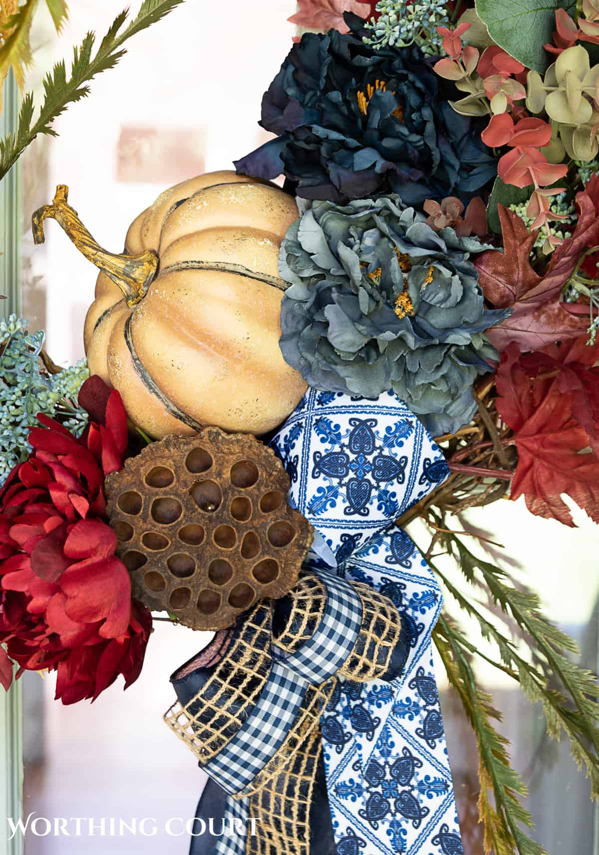 blue and burgundy fall front porch decor featuring a diy wreath, topiaries and faux mums