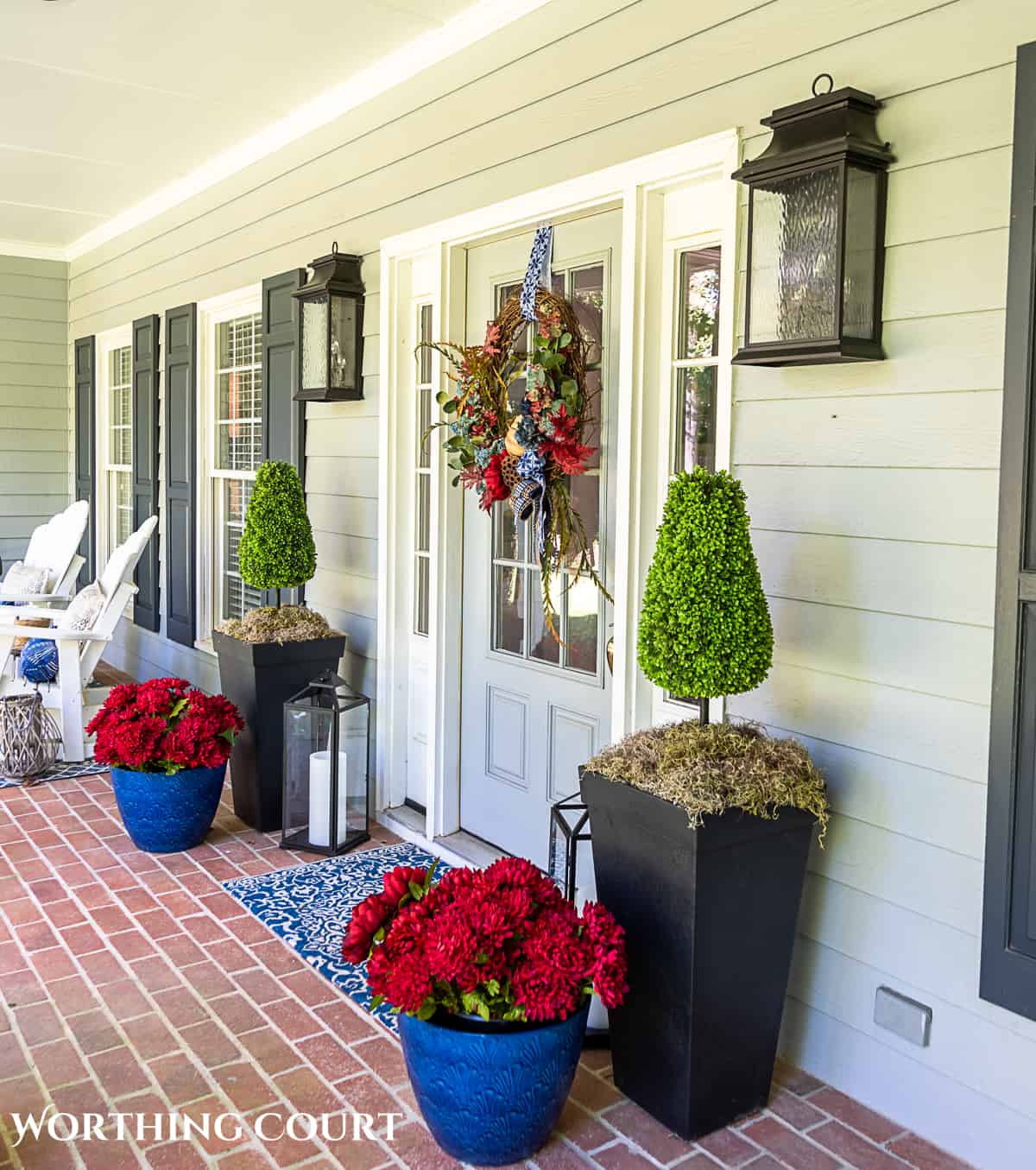 blue and burgundy fall front porch decor featuring a diy wreath, topiaries and faux mums