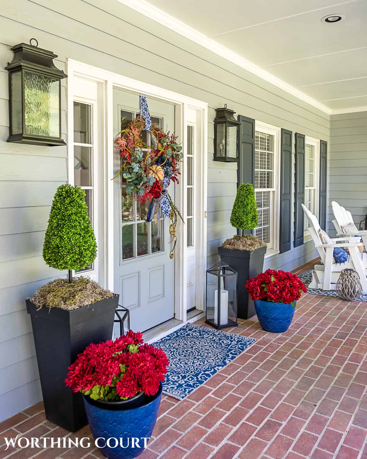 blue and burgundy fall front porch decor featuring a diy wreath, topiaries and faux mums