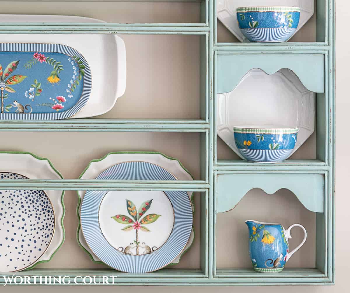 blue plate rack with blue and white dishes and tips for how to decorate a plate display rack with your favorite items