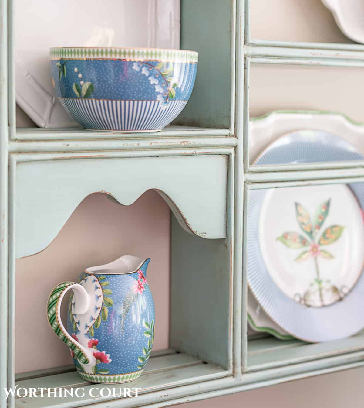 blue plate rack with blue and white dishes and tips for how to decorate a plate display rack with your favorite items