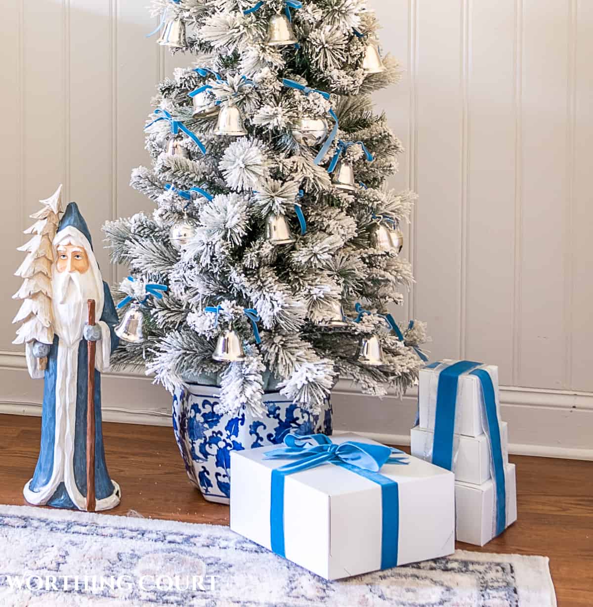 flocked Christmas tree in blue and white porcelain container decorated with French blue and silver ornaments and ribbon
