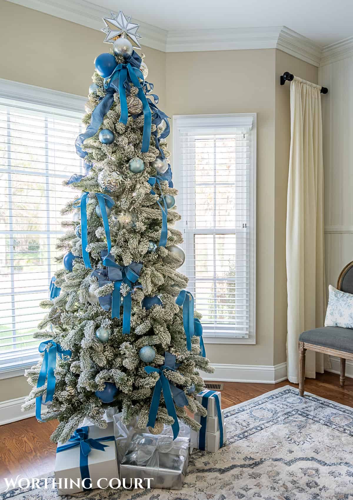flocked Christmas tree decorated with French blue and silver ornaments and ribbon